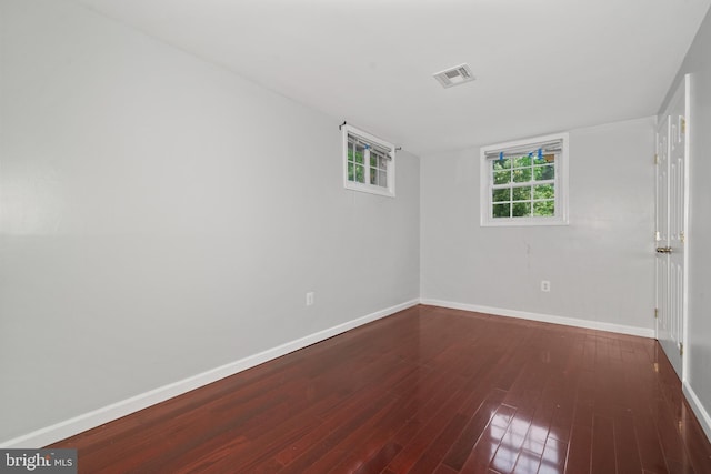 spare room with baseboards and wood finished floors