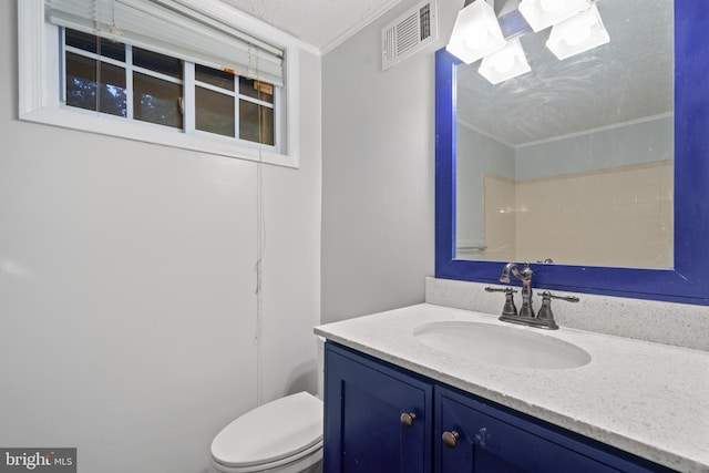 bathroom featuring ornamental molding, toilet, vanity, and a textured ceiling