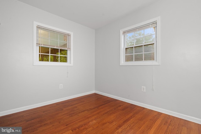 unfurnished room featuring baseboards and wood finished floors