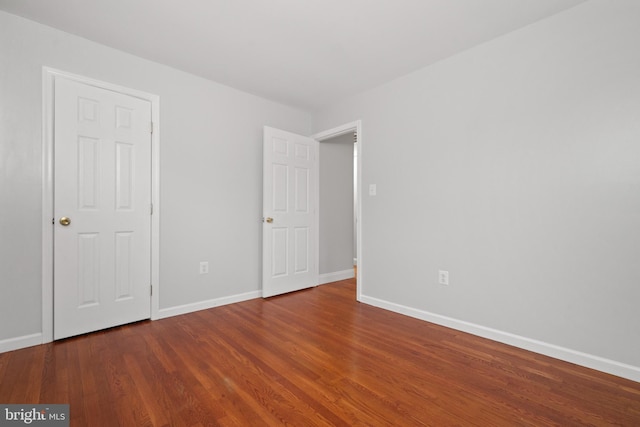 unfurnished bedroom featuring wood finished floors and baseboards