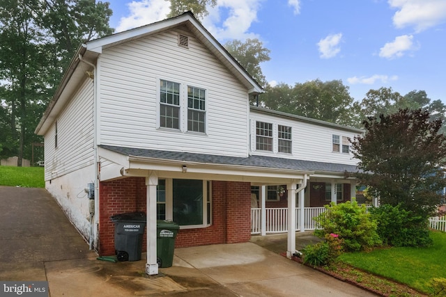 view of front of home with brick siding and covered porch