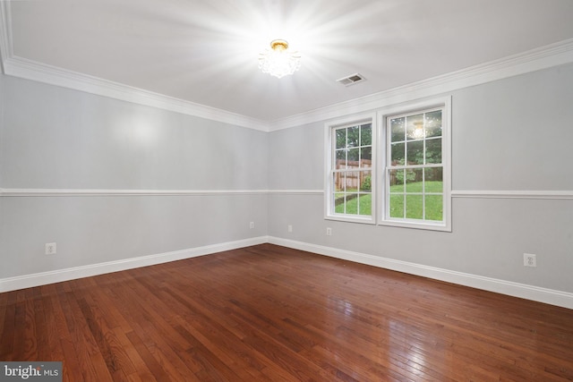 empty room with baseboards, hardwood / wood-style floors, ornamental molding, and a chandelier