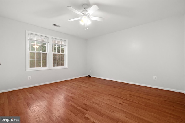 spare room with wood finished floors, baseboards, and ceiling fan