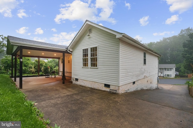 view of side of home with crawl space and a patio