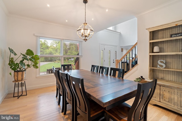 dining space with a chandelier, light wood finished floors, stairway, ornamental molding, and baseboards