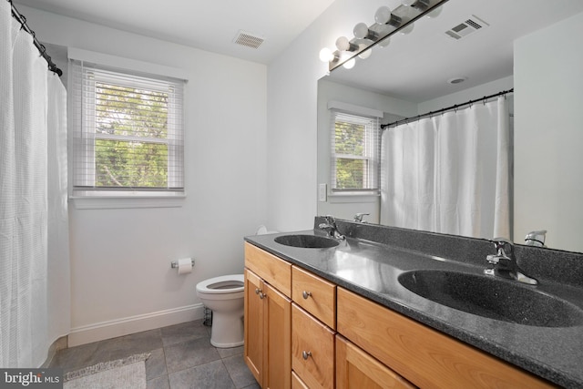 bathroom featuring baseboards, toilet, and double vanity
