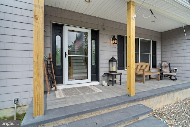 view of exterior entry featuring covered porch