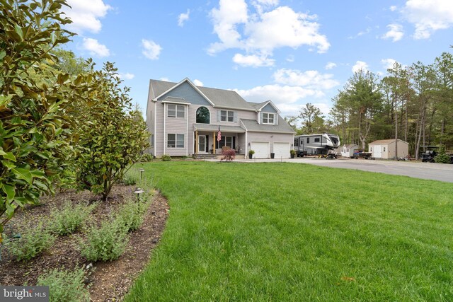view of front facade with asphalt driveway, an attached garage, and a front yard
