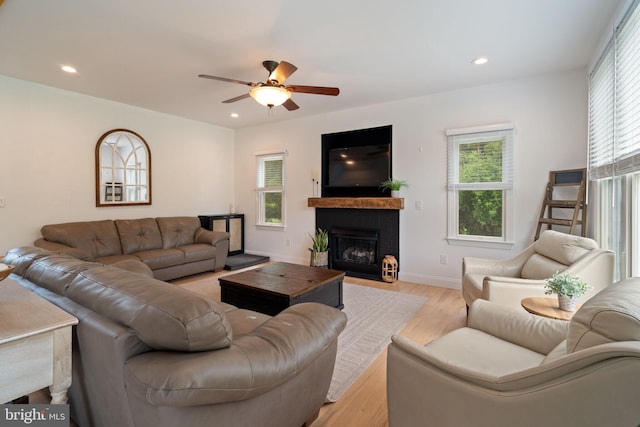 living room with ceiling fan, light wood-type flooring, a fireplace with flush hearth, recessed lighting, and baseboards
