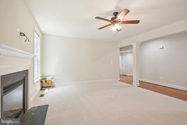 711 Bleak Hill Pl, Upper Marlboro, MD 20774 - unfurnished living room featuring ceiling fan, a fireplace with flush hearth, decorative columns, carpet flooring, and baseboards