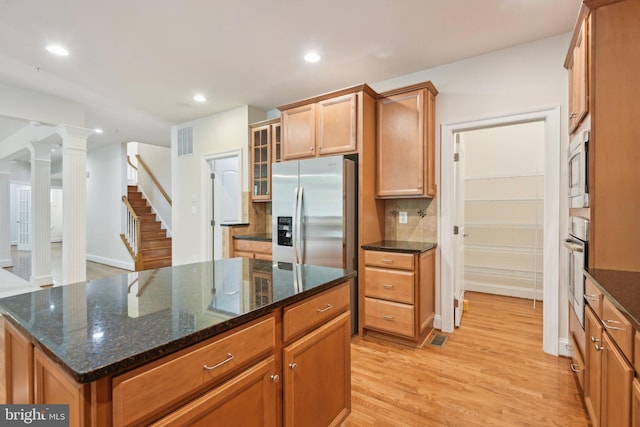 711 Bleak Hill Pl, Upper Marlboro, MD 20774 - kitchen with stainless steel appliances, light wood finished floors, tasteful backsplash, glass insert cabinets, and brown cabinets