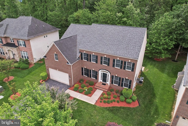 711 Bleak Hill Pl, Upper Marlboro, MD 20774 - view of front facade featuring an attached garage, asphalt driveway, a front lawn, a shingled roof, and brick siding