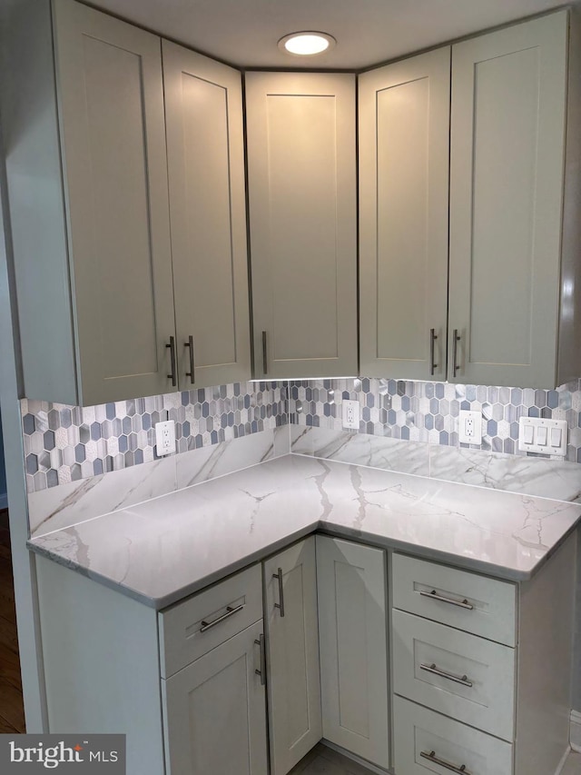 kitchen featuring backsplash and light stone counters