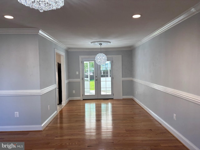 unfurnished dining area with a chandelier, wood finished floors, recessed lighting, baseboards, and crown molding