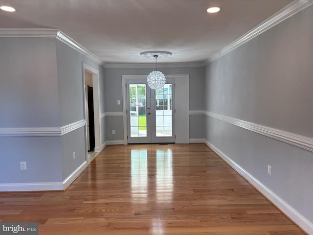 unfurnished dining area with a chandelier, wood finished floors, baseboards, recessed lighting, and crown molding
