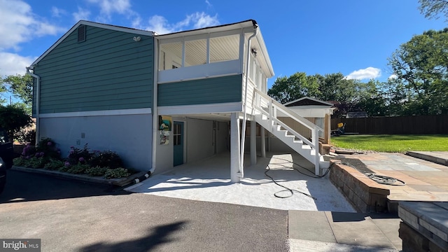 view of side of home featuring stairway, a carport, and a patio