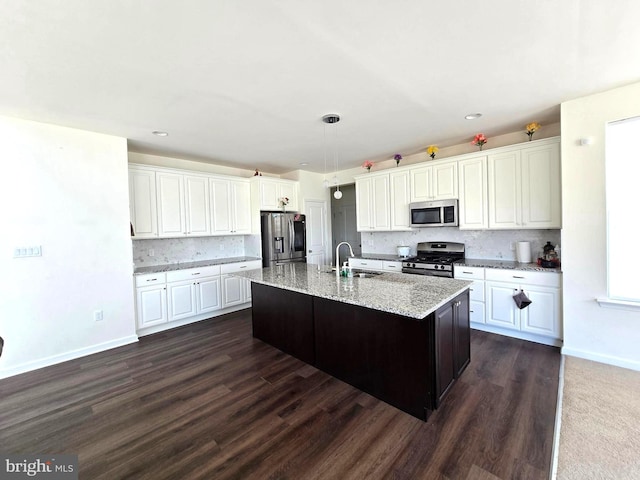kitchen with stainless steel appliances, a sink, decorative backsplash, white cabinetry, and recessed lighting