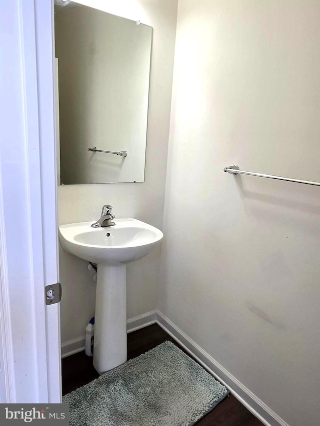 bathroom with baseboards and wood finished floors