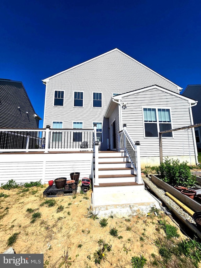 back of house featuring a wooden deck and a vegetable garden