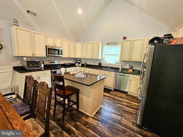 3612 Panhandle Rd, Front Royal, VA 22630 - kitchen with stainless steel appliances, a sink, high vaulted ceiling, cream cabinetry, and dark wood-style floors
