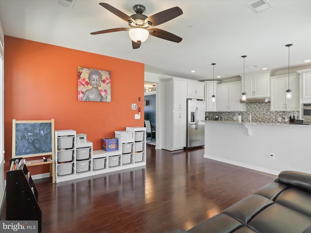 living area featuring a ceiling fan, dark wood-type flooring, and recessed lighting