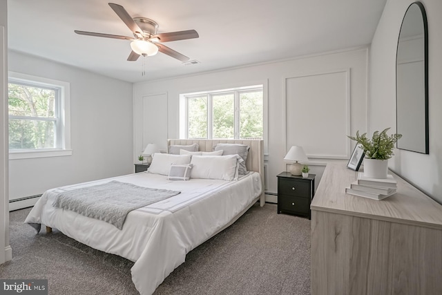 carpeted bedroom featuring a baseboard heating unit and a ceiling fan