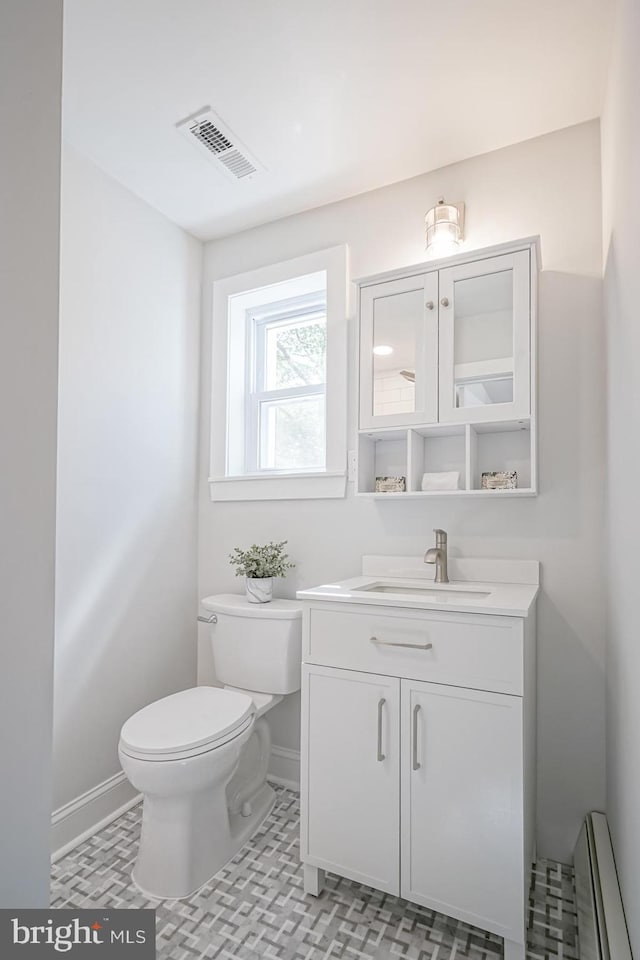 bathroom featuring toilet, baseboards, vanity, and baseboard heating