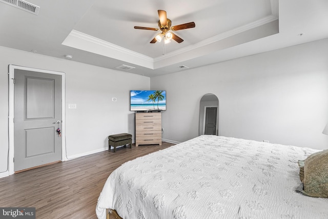 9508 Mourning Dove Way, Delmar, MD 21875 - bedroom featuring a raised ceiling, wood finished floors, crown molding, baseboards, and arched walkways
