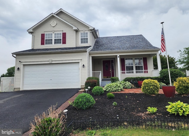 view of front of property with covered porch, a garage, and asphalt driveway