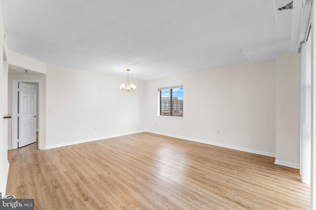 24 Courthouse Sq Unit 710, Rockville, MD 20850 - empty room with a chandelier, light wood-style floors, and baseboards
