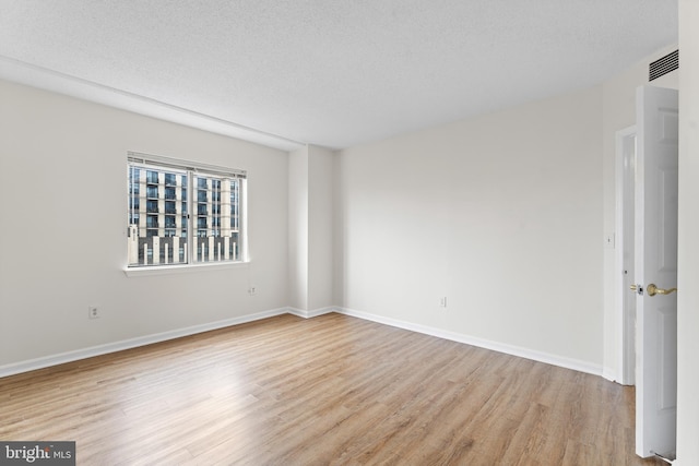 24 Courthouse Sq Unit 710, Rockville, MD 20850 - empty room featuring light wood-type flooring, baseboards, and a textured ceiling