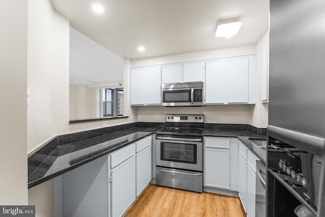 24 Courthouse Sq Unit 710, Rockville, MD 20850 - kitchen with stainless steel appliances, white cabinetry, light wood finished floors, dark stone countertops, and recessed lighting
