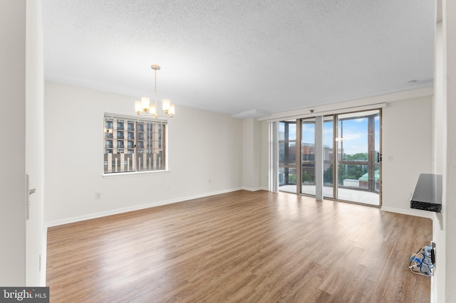 24 Courthouse Sq Unit 710, Rockville, MD 20850 - unfurnished living room featuring a chandelier, a textured ceiling, wood finished floors, and baseboards