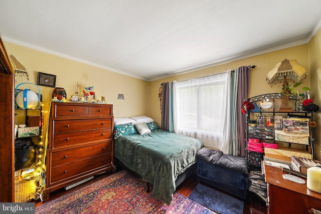 bedroom with crown molding and wood finished floors