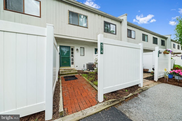 back of property featuring central air condition unit and fence