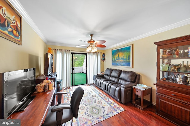 living area with ceiling fan, wood finished floors, ornamental molding, a desk, and baseboards