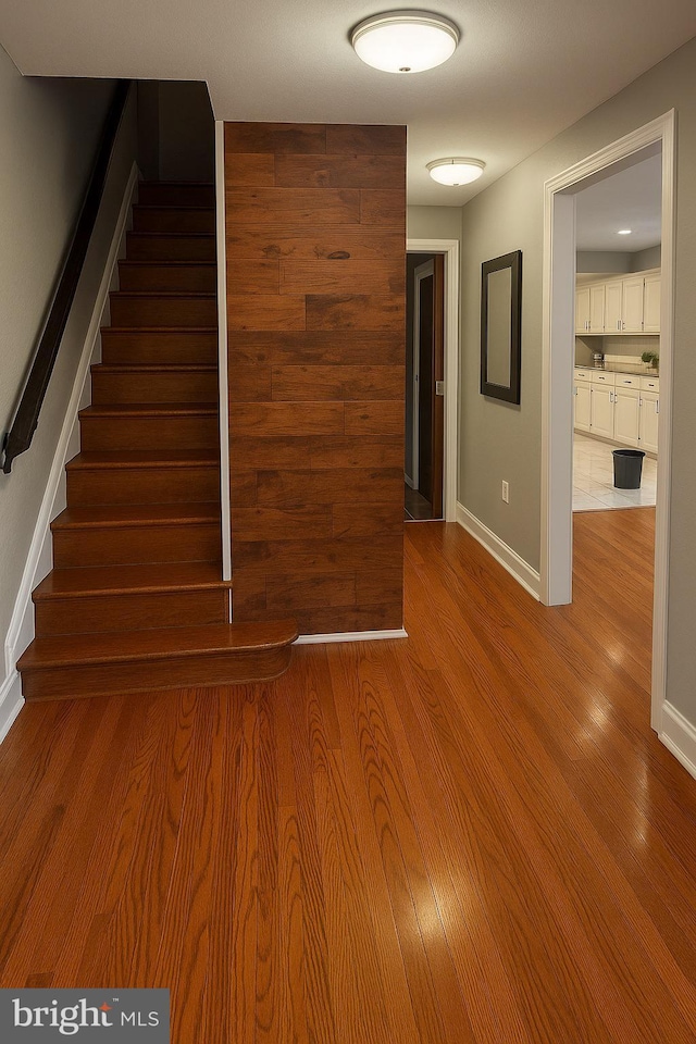 stairway with baseboards and wood finished floors