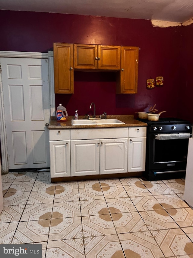 3952 N Franklin St, Philadelphia, PA 19140 - kitchen with a sink, black gas range oven, white cabinets, dark countertops, and light tile patterned floors