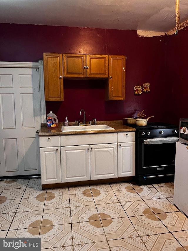 3952 N Franklin St, Philadelphia, PA 19140 - kitchen with black gas stove, a sink, white cabinetry, dark countertops, and light tile patterned floors