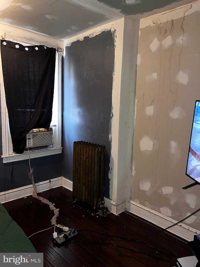 3952 N Franklin St, Philadelphia, PA 19140 - detailed view of radiator heating unit, wood finished floors, cooling unit, and baseboards