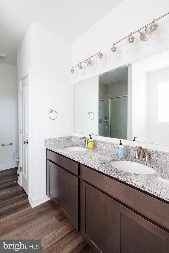 205 Kinneman Rd, Abbottstown, PA 17301 - full bathroom with wood finished floors, a stall shower, toilet, double vanity, and baseboards