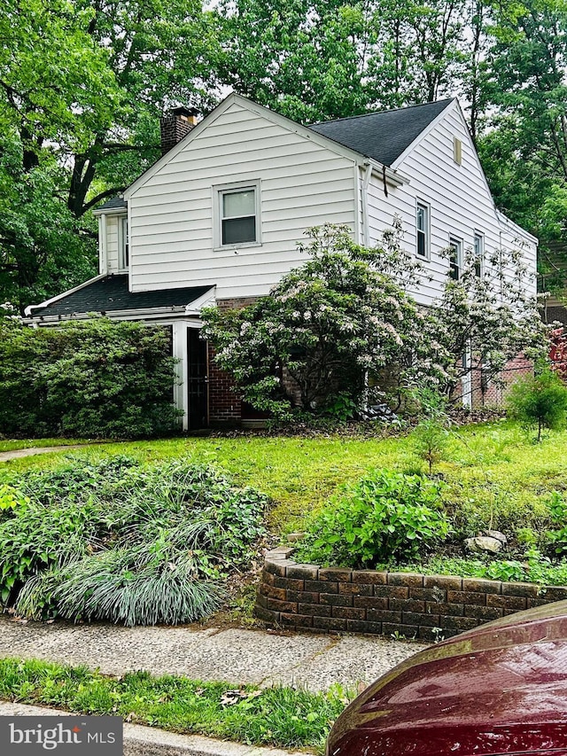 239 Glentay Ave, Lansdowne, PA 19050 - view of side of property featuring a chimney, a shingled roof, and view of scattered trees