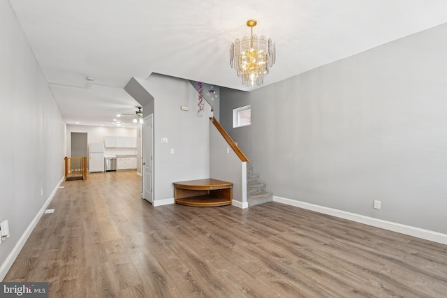 1609 N Hilton St, Baltimore, MD 21216 - unfurnished living room with wood finished floors, stairs, a chandelier, and a ceiling fan
