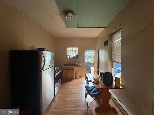 kitchen with freestanding refrigerator, stainless steel electric stove, light wood finished floors, and plenty of natural light