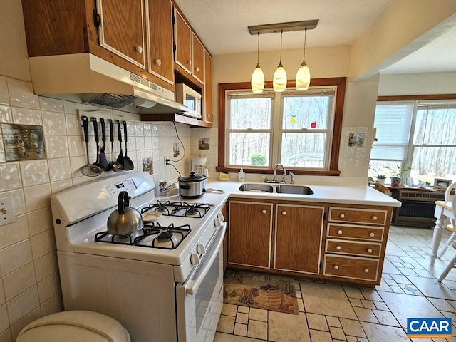 419 Camden St, Dillwyn, VA 23936 - kitchen featuring white gas range, brown cabinetry, a sink, under cabinet range hood, and light countertops