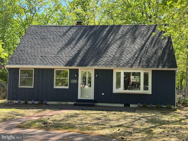 view of front of property with entry steps, roof with shingles, and a chimney