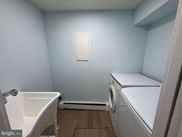 laundry area featuring a baseboard heating unit, independent washer and dryer, wood finished floors, and electric panel