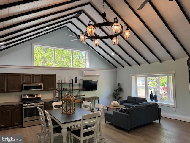 dining space with beamed ceiling, high vaulted ceiling, light wood-style flooring, an AC wall unit, and a chandelier