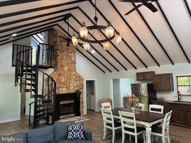 dining room with wood finished floors, high vaulted ceiling, a ceiling fan, stairs, and beamed ceiling