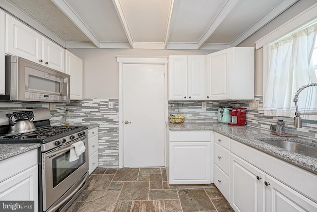1117 Tatum St, Woodbury, NJ 08096 - kitchen with appliances with stainless steel finishes, a sink, backsplash, white cabinetry, and crown molding